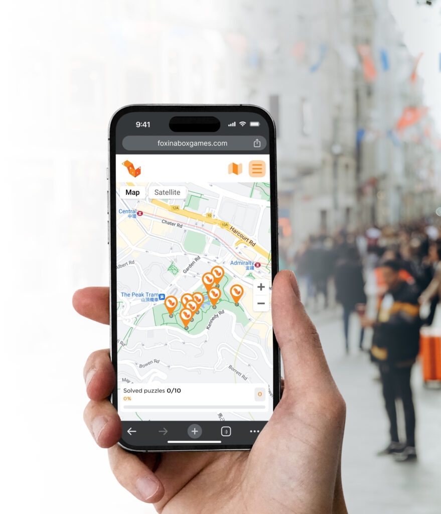 Hand holding a phone displaying the Fox Hunt geo-location puzzle game map in Hong Kong’s Admiralty area.