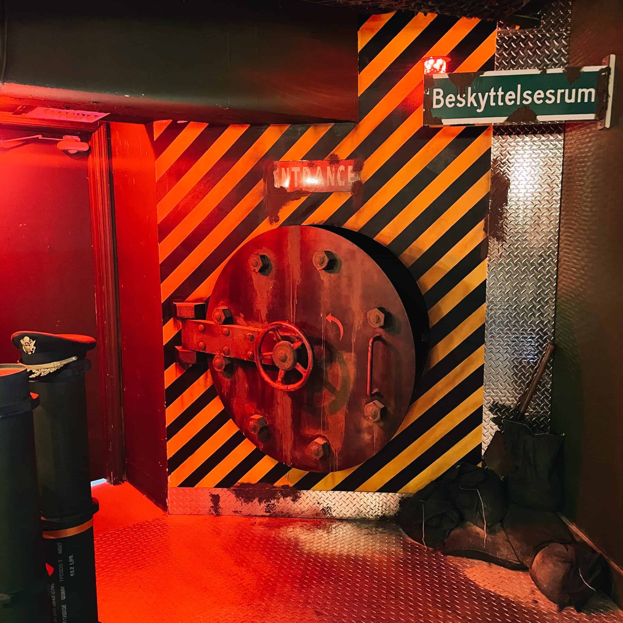 Escape room themed vault door with warning signs at Fox in a Box Miami.