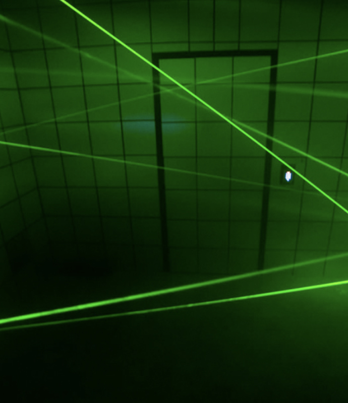 Laser tag game with green laser beams in a dark room at Fox in a Box Stockholm.