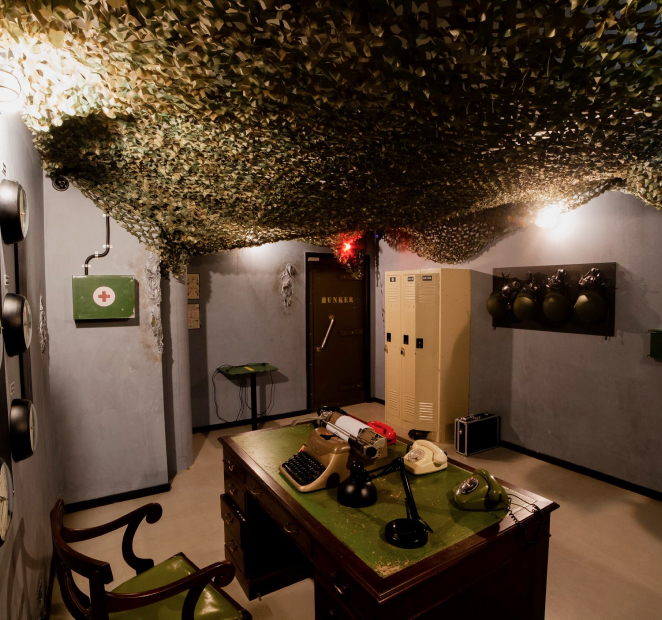 Abandoned military office room with vintage equipment, typewriter, radios, and lockers, part of futuristic escape room in Stockholm.