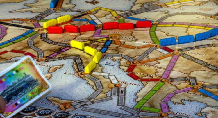 Colorful train pieces and game tokens on a detailed map for the Roomescape by Fox in a Box Stockholm.