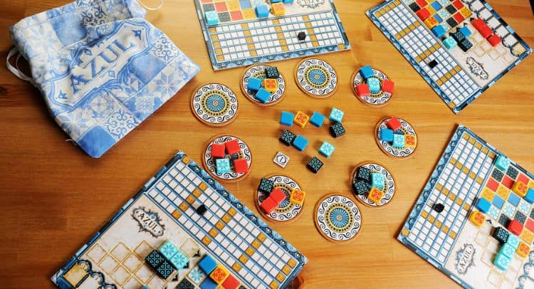 Wooden tabletop with colorful tiles and game pieces from Roomescape by Fox in a Box Stockholm, showing an immersive escape room setup.